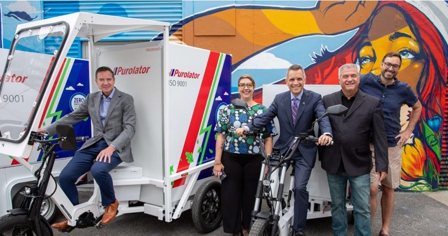 Purolator team and delivery trucks with colorful murals, representing reliable document delivery service
